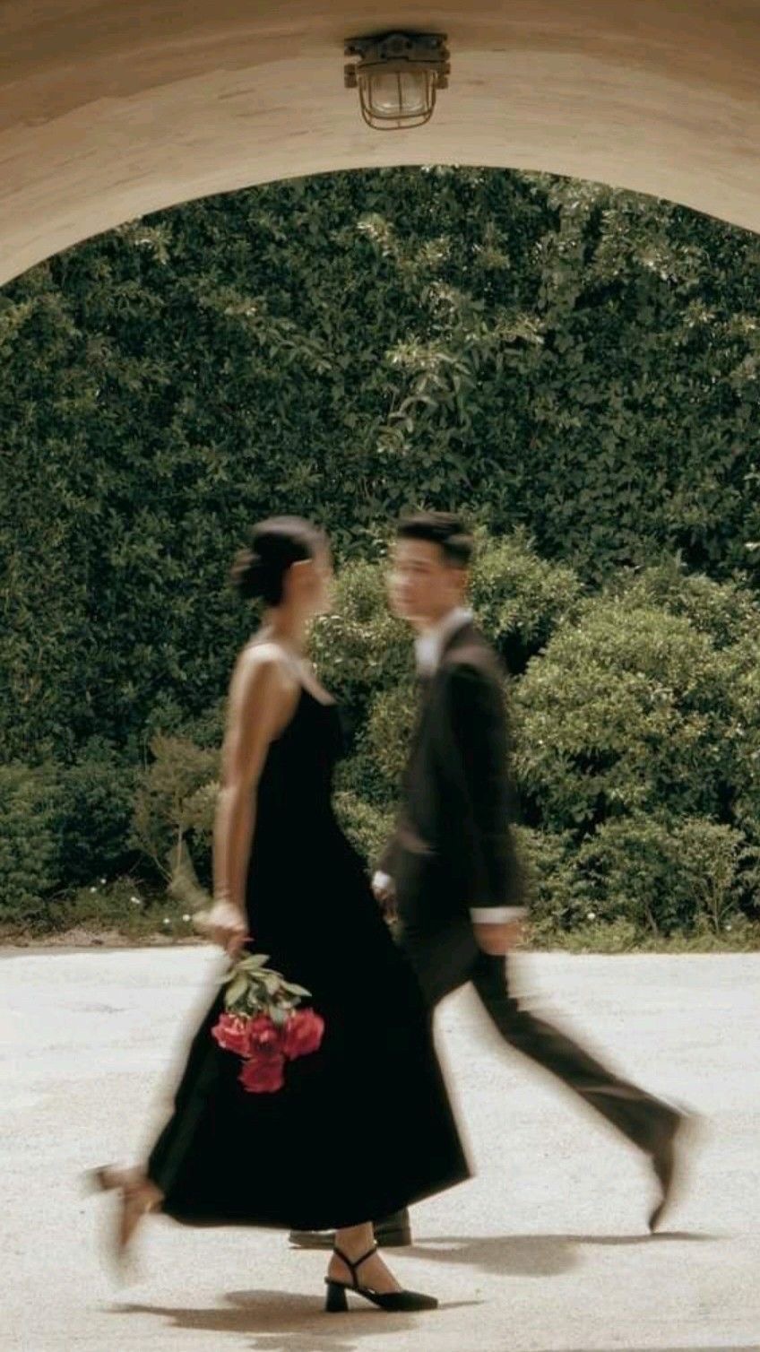 Pareja caminando frente a un jardín en movimiento